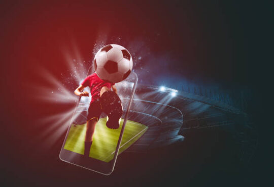 Soccer players, cellphone and ball on a stadium
