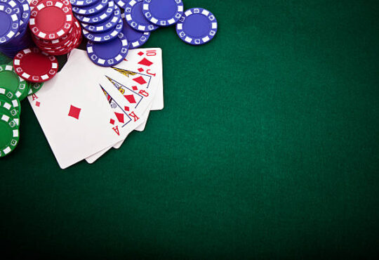 Royal flush and gambling chip on a green poker table