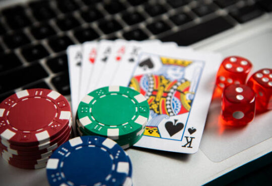 Poker chips and cards on computer keyboard