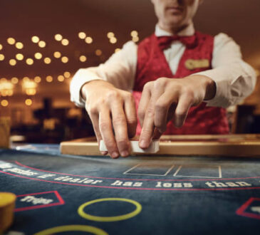 The croupier holds poker cards in his hands at a table in a casino.
