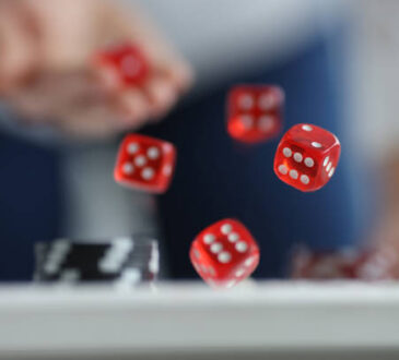 Man throws red dice on table and chips. Casino game and luck