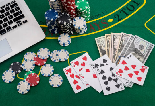 poker chips with banknotes placed on a laptop keyboard. Poker concept