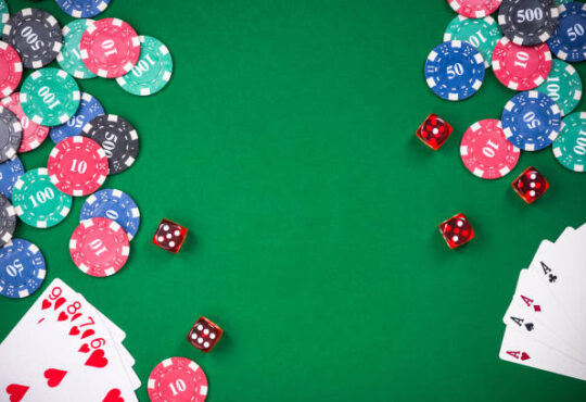Casino games related items on green table, copy space.