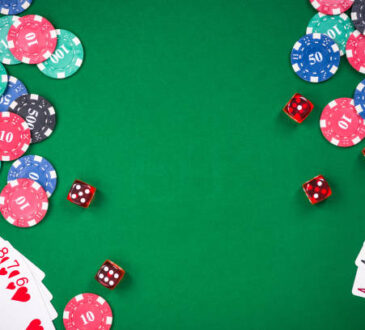 Casino games related items on green table, copy space.
