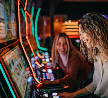Girl friends gambling in casino on slot machinery