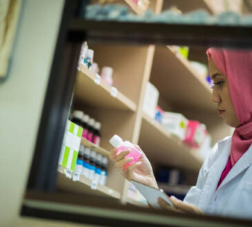 Female Muslim Pharmacist filing a prescription