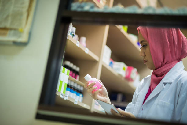 Female Muslim Pharmacist filing a prescription